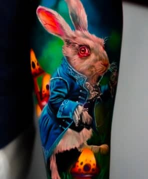 A realistic tattoo of a white rabbit with red eyes wearing a blue coat, standing on a mushroom.