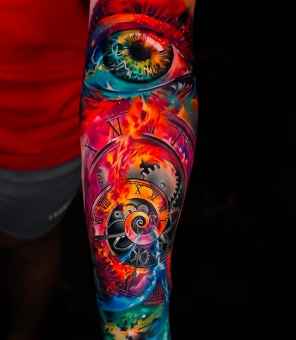 A vibrant, colorful tattoo on an arm shows an eye, clocks, and gears against a fiery, cosmic background.